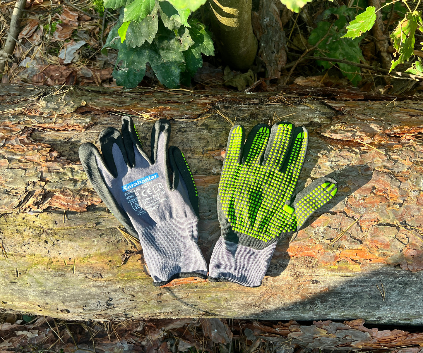 Super flexible Handschuhe in schwarz/grauer Farbe mit grünen Noppen im Wald