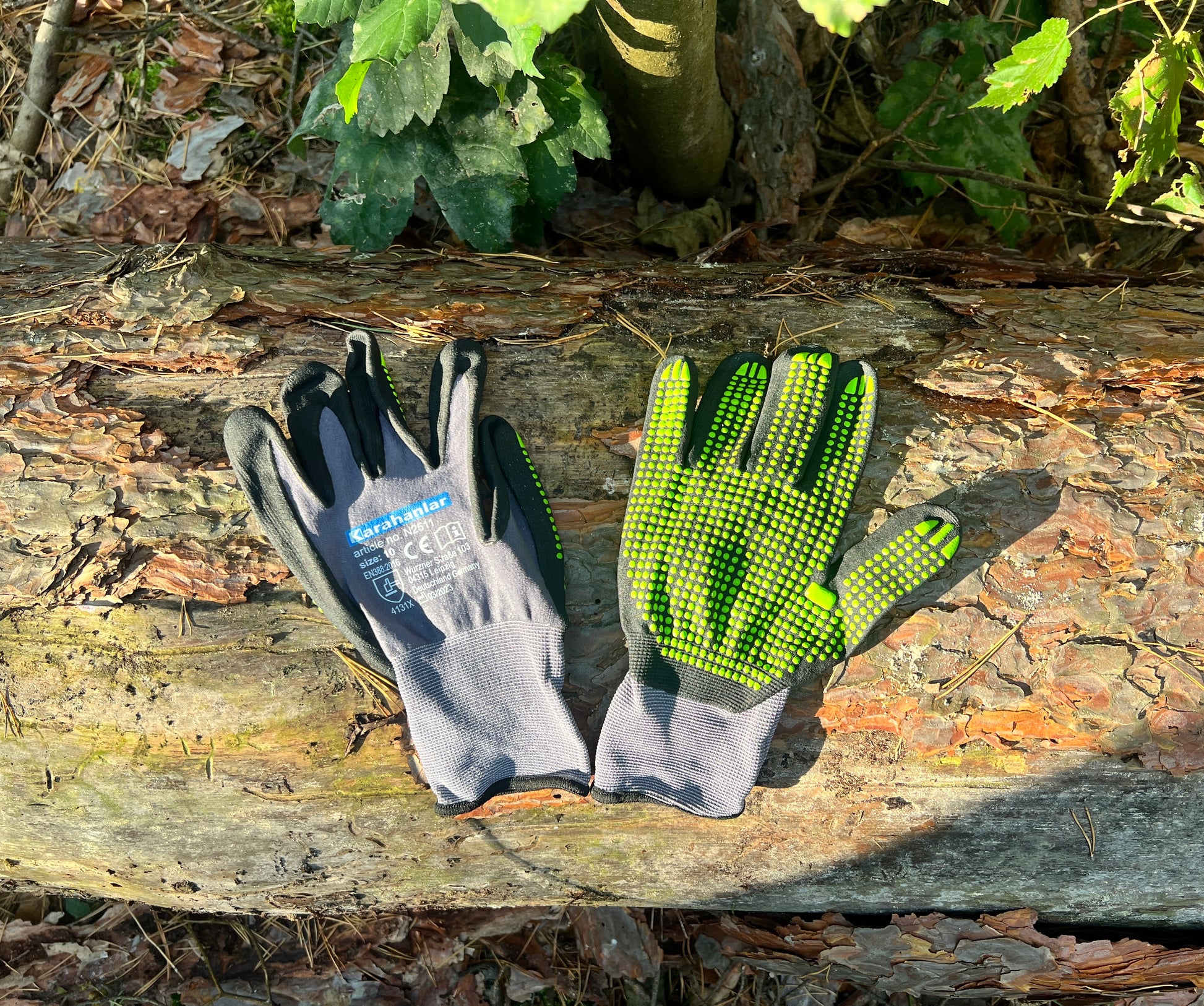 Super flexible Handschuhe in schwarz/grauer Farbe mit grünen Noppen im Wald