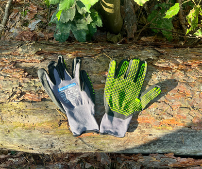 Super flexible Handschuhe in schwarz/grauer Farbe mit grünen Noppen im Wald