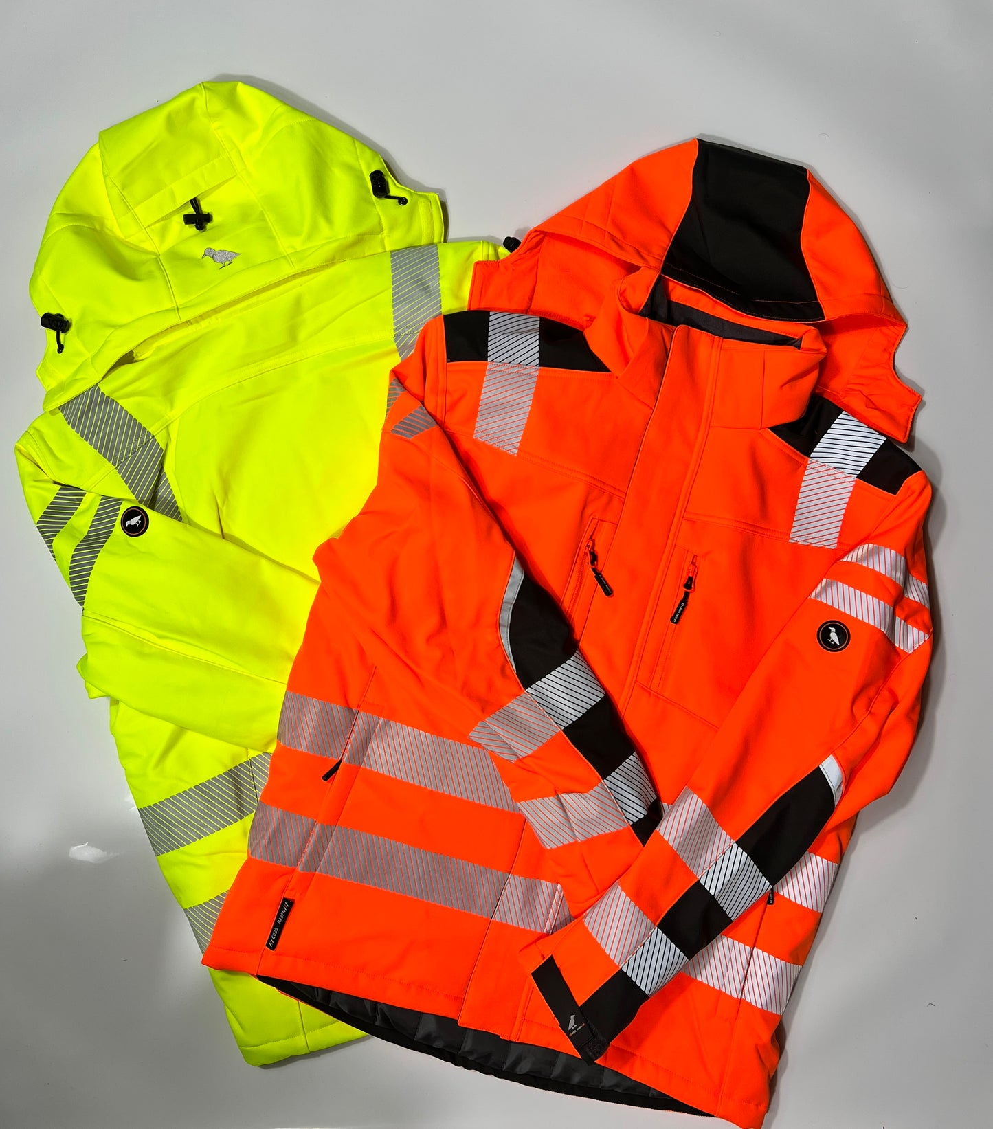 Zwei Softshelljacken in Warnfarbe aufeinanderliegend