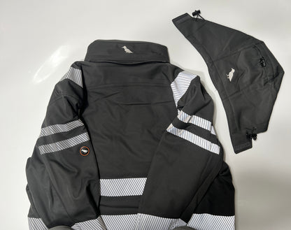 Eine schwarze Kapuze liegt neben der schwarzen Softshelljacke mit Reflektoren