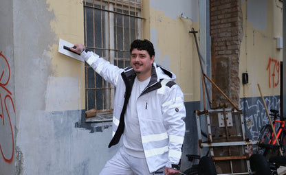 Ein Mann mit weißer Arbeitsjacke mit Reflektoren