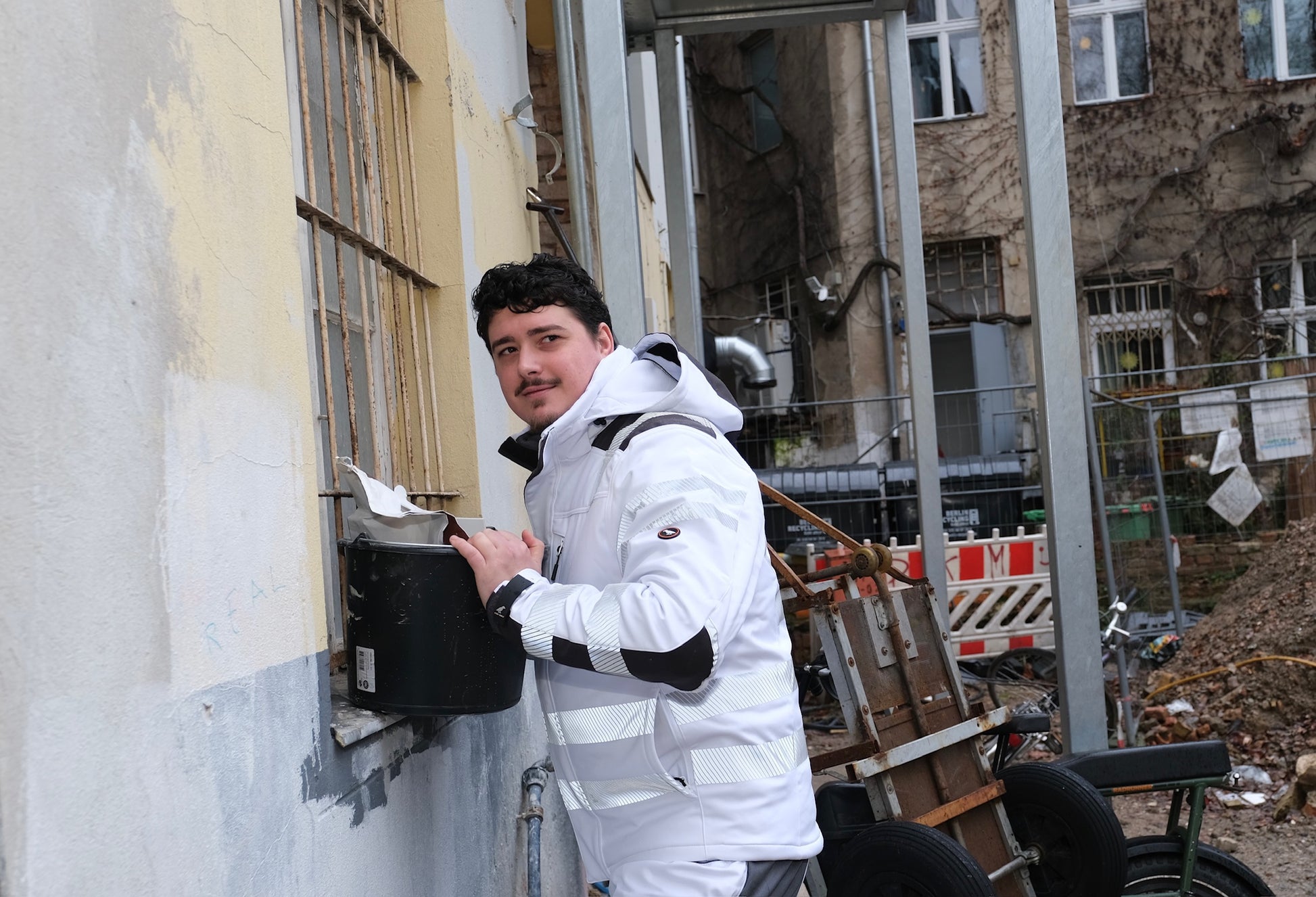 Ein Mann mit weißer Arbeitsjacke mit Reflektoren
